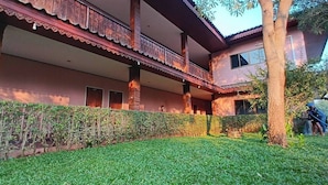 A two-story building with a balcony and a well-maintained garden. - Sukhothai Grand Hotel and Landmark (Sukhothai)