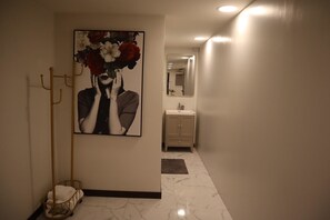 A hallway with a marble floor, a beige cabinet, and a framed artwork on the wall. - Peema Villa (U Thong)