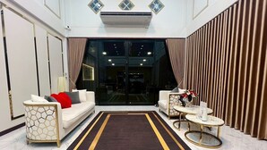 A modern living room with a sofa, armchairs, a coffee table, and a rug. - Peema Villa (U Thong)