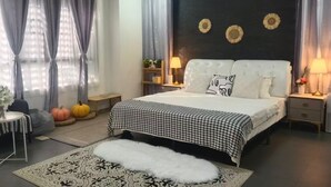 Ein Schlafzimmer mit einem Bett, zwei Nachttischen, einem Beistelltisch, einem gemusterten Teppich und Wanddekoration.
