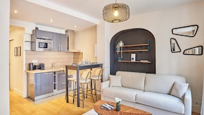 Une cuisine moderne avec un coin repas, un canapé et une table basse.