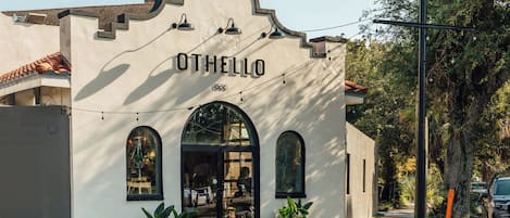 A building with the name 'OTHELLO' on the facade, featuring arched windows and a tiled roof.