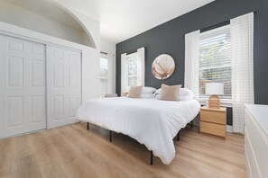 A bedroom with a bed, bedside tables, a lamp, and a wall-mounted picture.