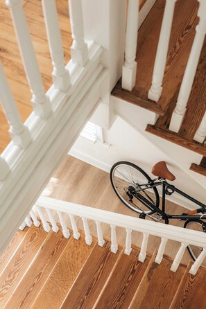 A wooden staircase with white balusters and a bicycle leaning against it.