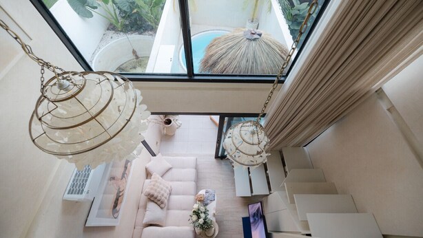 A modern interior with a glass ceiling, a pool, and a staircase.