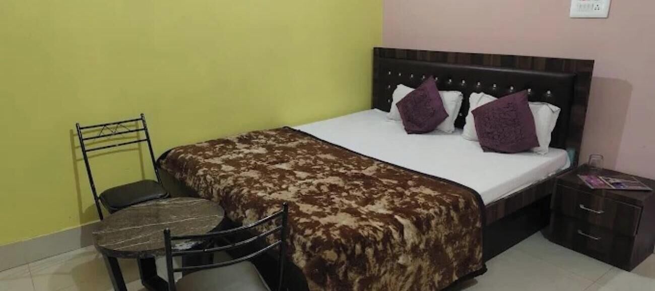 Un dormitorio con cama, una silla, una mesita de noche y una pequeña mesa.