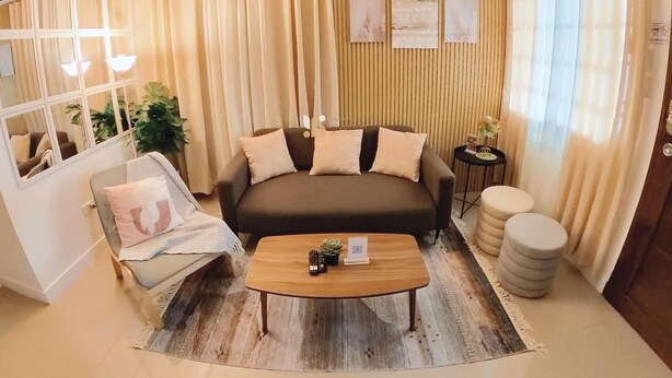 Una sala de estar con sofá, sillón, mesa de centro y una mesita auxiliar.