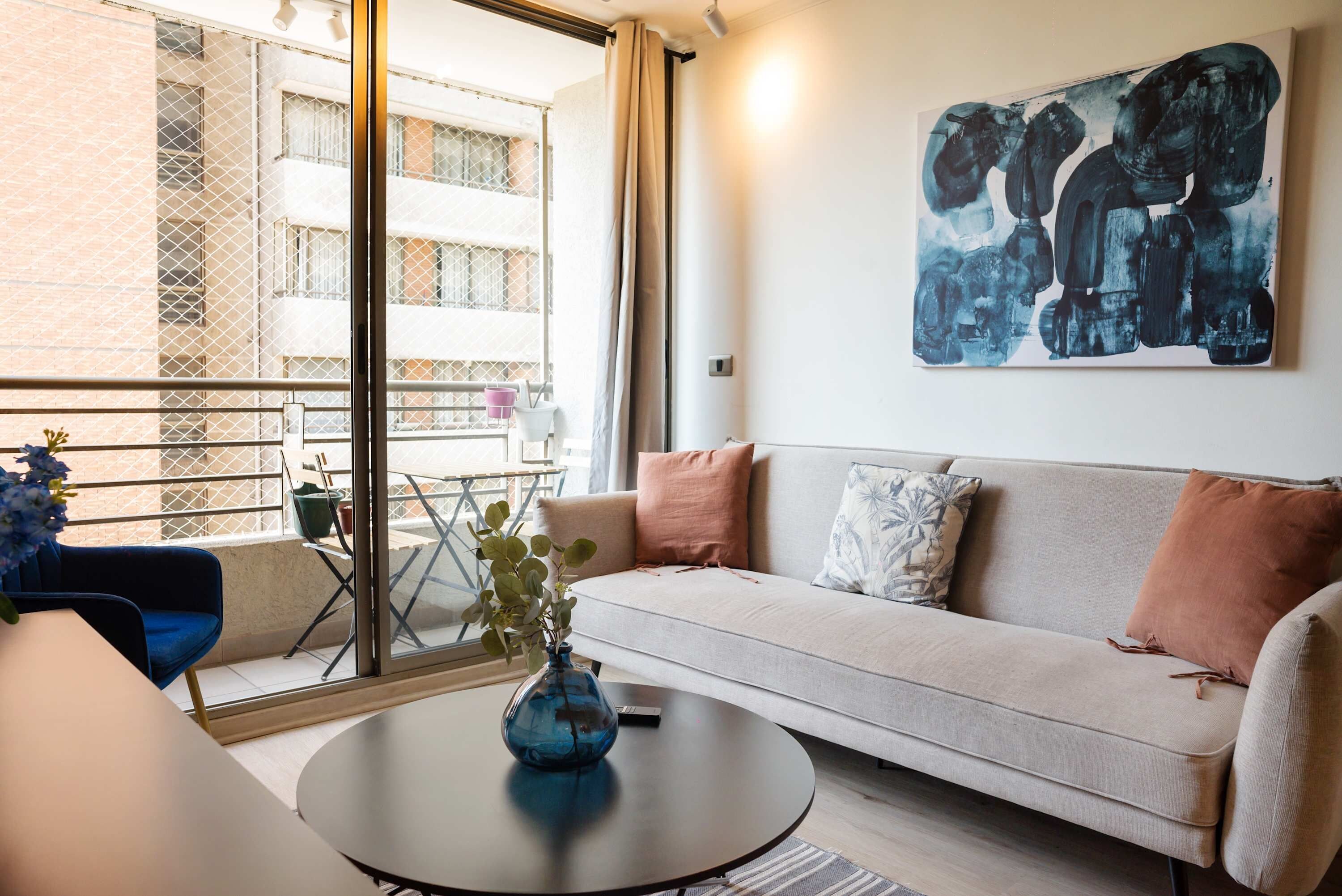 Een moderne woonkamer met een bank, een salontafel en een schilderij aan de muur.