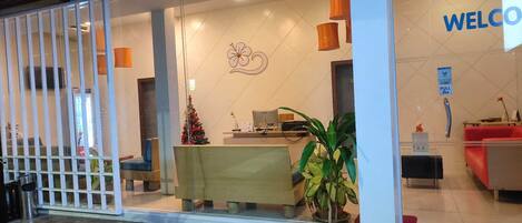 A reception area with a desk, a Christmas tree, and a 'WELCOME' sign.