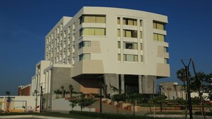 Un hotel moderno de varios pisos con techo plano, ventanas amplias y una entrada central.