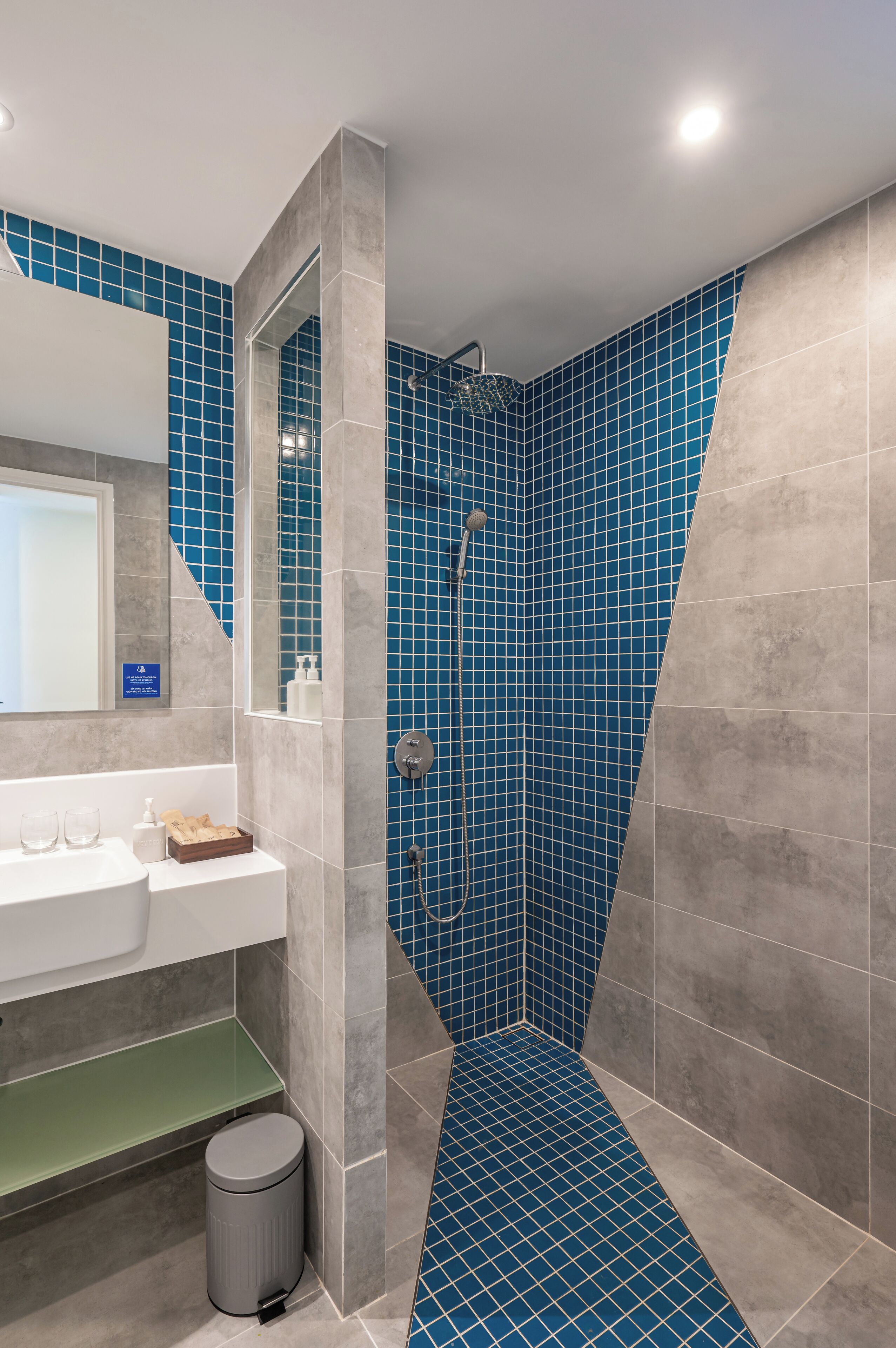 A bathroom with a shower, a sink, and a mirror.