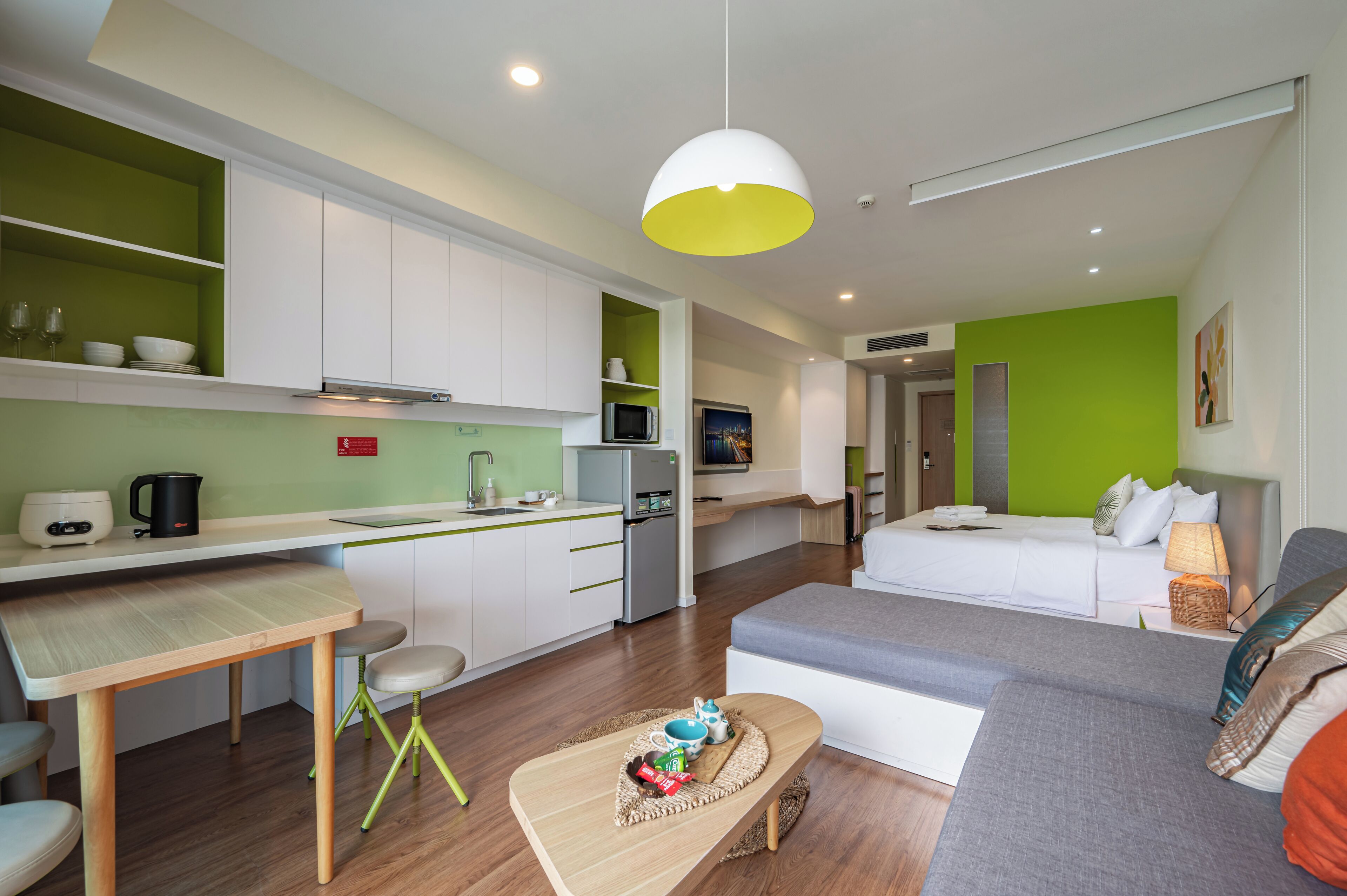 Een moderne hotelkamer met kitchenette, een eethoek en een zithoek.