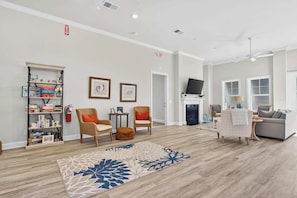 A spacious living room with a fireplace, comfortable seating, and a bookshelf. - 4BR Townhouse with Golf View in Ocean Isle Beach (Ocean Isle Beach)