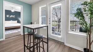 A compact living space with a dining area, a bed, and a balcony with a view. - Apartment w/pool & hot tub + gym (Austin)