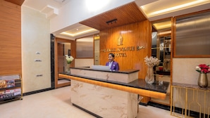 Un mostrador de recepción con encimera de mármol, paneles de madera y un letrero que dice "Park Avenue Hotel".