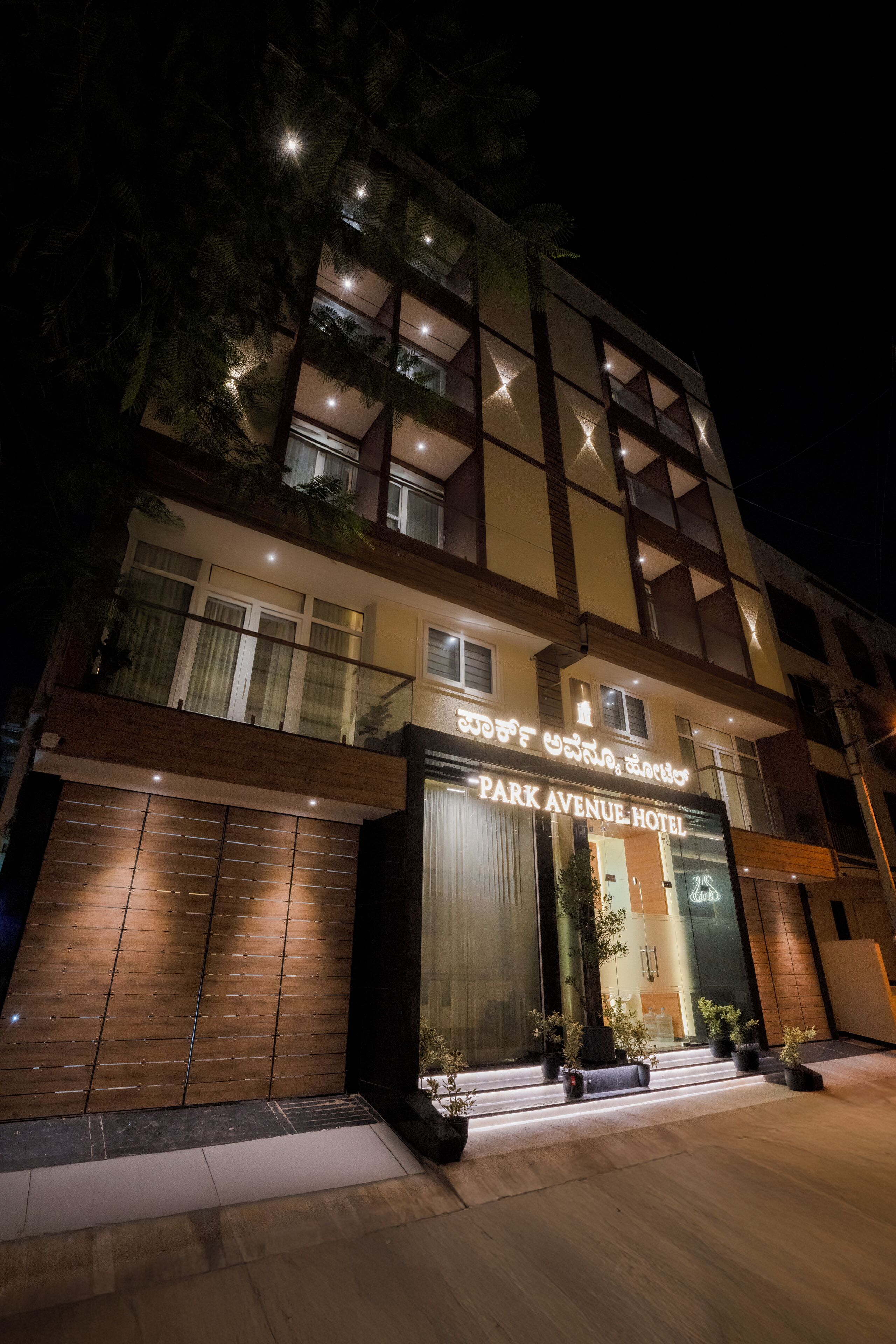 A multi-story hotel with a modern facade, large glass windows, and a prominent entrance with a sign.