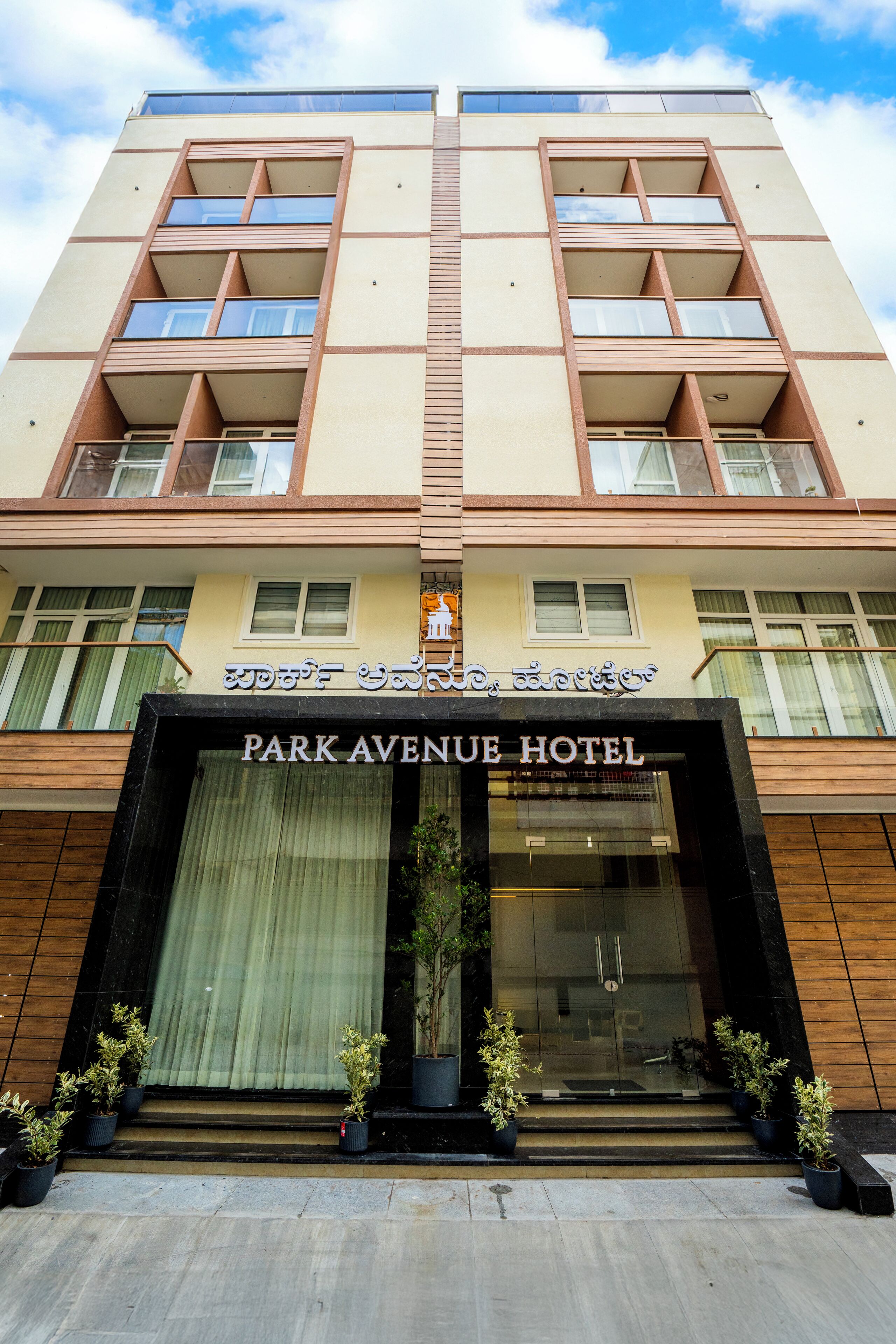 A multi-story hotel with a prominent entrance, balconies, and a sign indicating it is the Park Avenue Hotel.