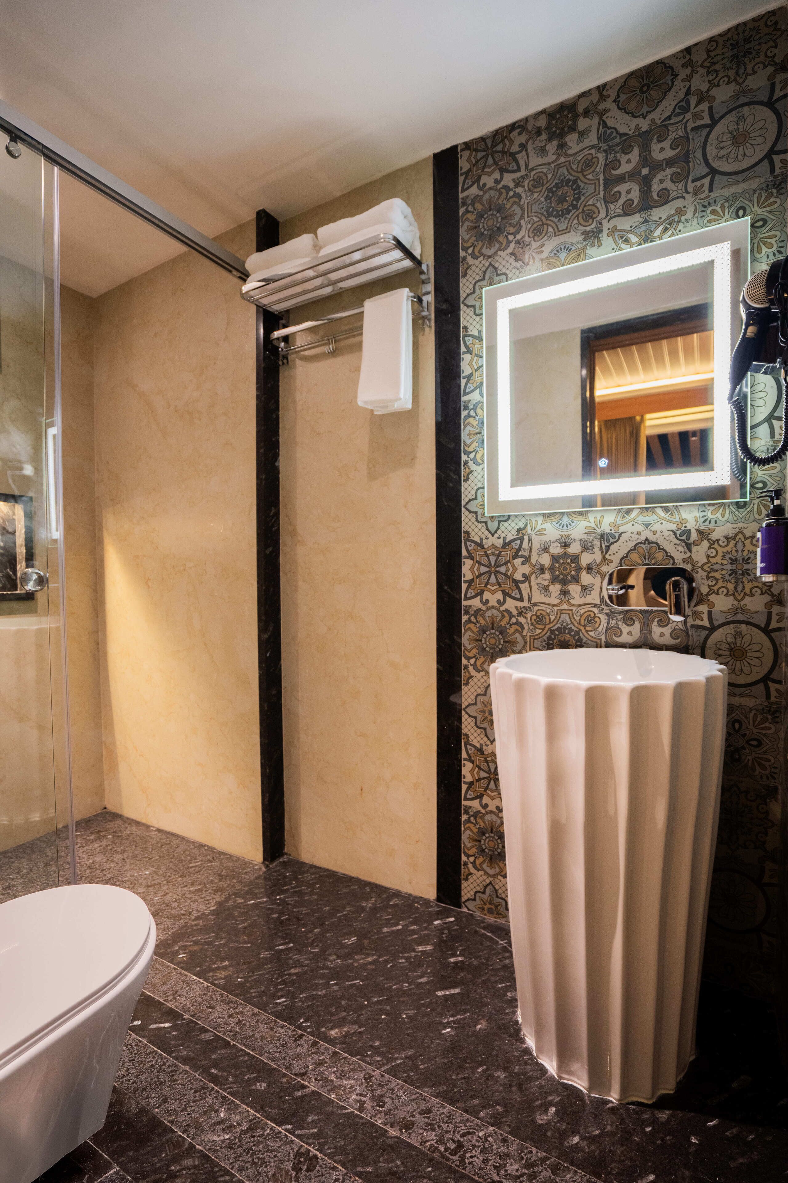 Een badkamer met een douchecabine van glas, een wit wastafelmeubel met spiegel en een toilet.