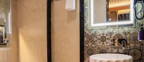 Een badkamer met een douchecabine van glas, een wit wastafelmeubel met spiegel en een toilet.