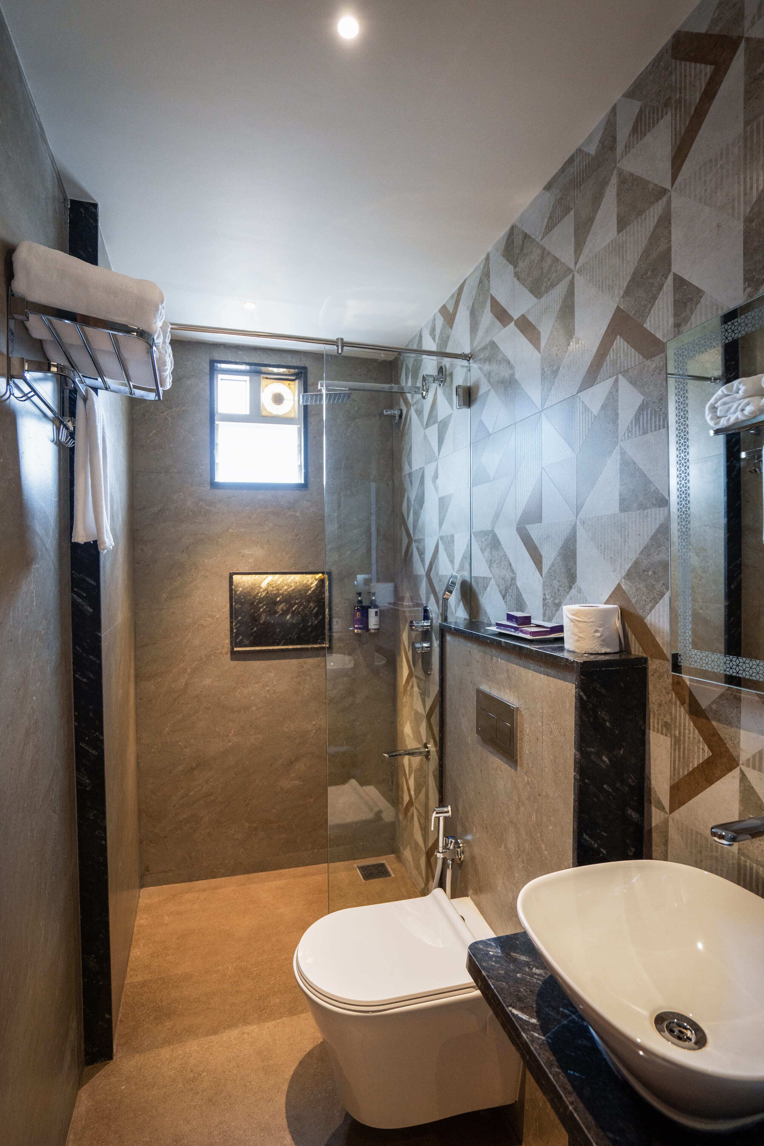 Un bagno moderno con doccia in vetro, un water bianco e un lavandino in marmo.