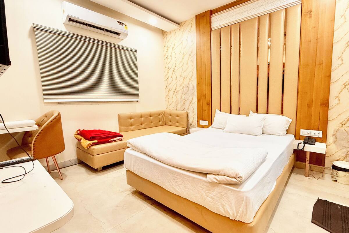 Une chambre d’hôtel moderne avec un grand lit, un bureau, une chaise et une petite table.