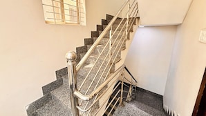 Una escalera con barandillas de metal y escalones de granito.