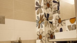 A bathroom with a toilet, sink, and shower area. - Alba in Cento (Lampedusa)