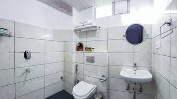 Chuveiro, chinelos, toalhas de banho, sabonete