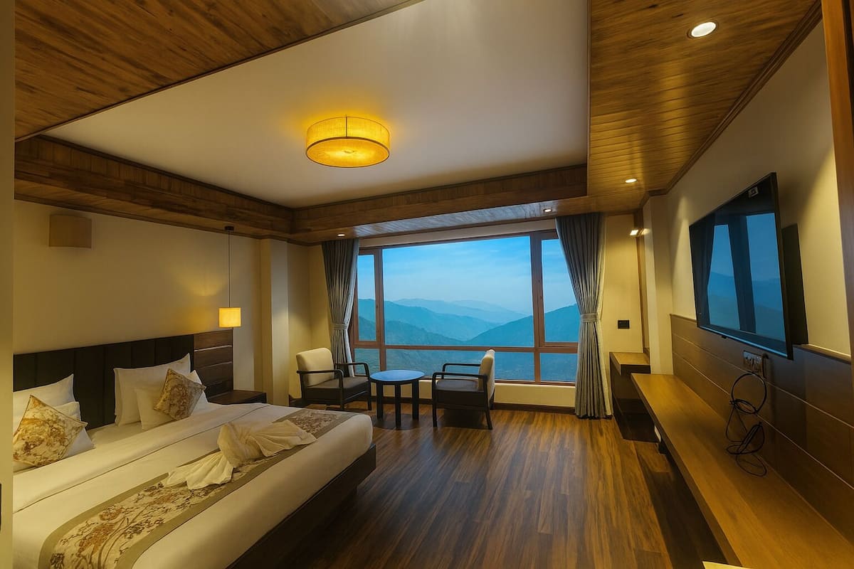 Habitación de hotel con una cama grande, un escritorio, una silla y un televisor. La habitación tiene piso de madera y un ventanal con vistas a la montaña.