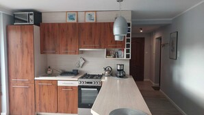 Een moderne keuken met houten kastjes, een inbouwfornuis en een groot eiland.