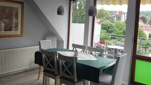 Een eetruimte met een tafel voor vier personen, witte stoelen en hanglampen.