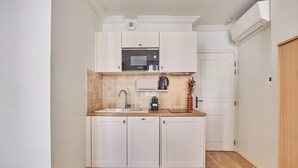 A compact kitchen with white cabinets, a microwave, a coffee maker, and a sink. - Superb Studio Center of Paris Montorgueil (Paris)