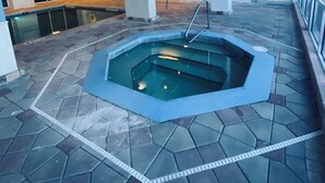 A swimming pool with a geometric design, surrounded by a tiled floor and walls. - Coastal Waves Ocean View Studio condo (Daytona Beach)