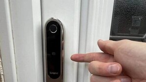Eine moderne Tür mit Tastsensor-Schloss und einer Metallhandle.