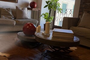 Un salon avec une table basse ronde, un objet sphérique rouge et une plante en pot.