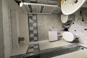 Een moderne badkamer met douche, toilet en wastafel.