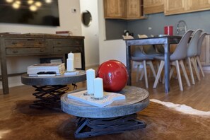 Een eetruimte met een tafel en stoelen, een rode bol op een tafel, en een houten kast op de achtergrond.