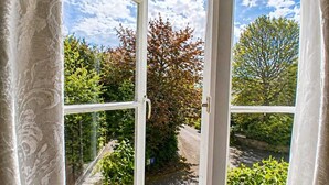 An open window with a view of a garden and a road. - Tree Hotel (Oxford)