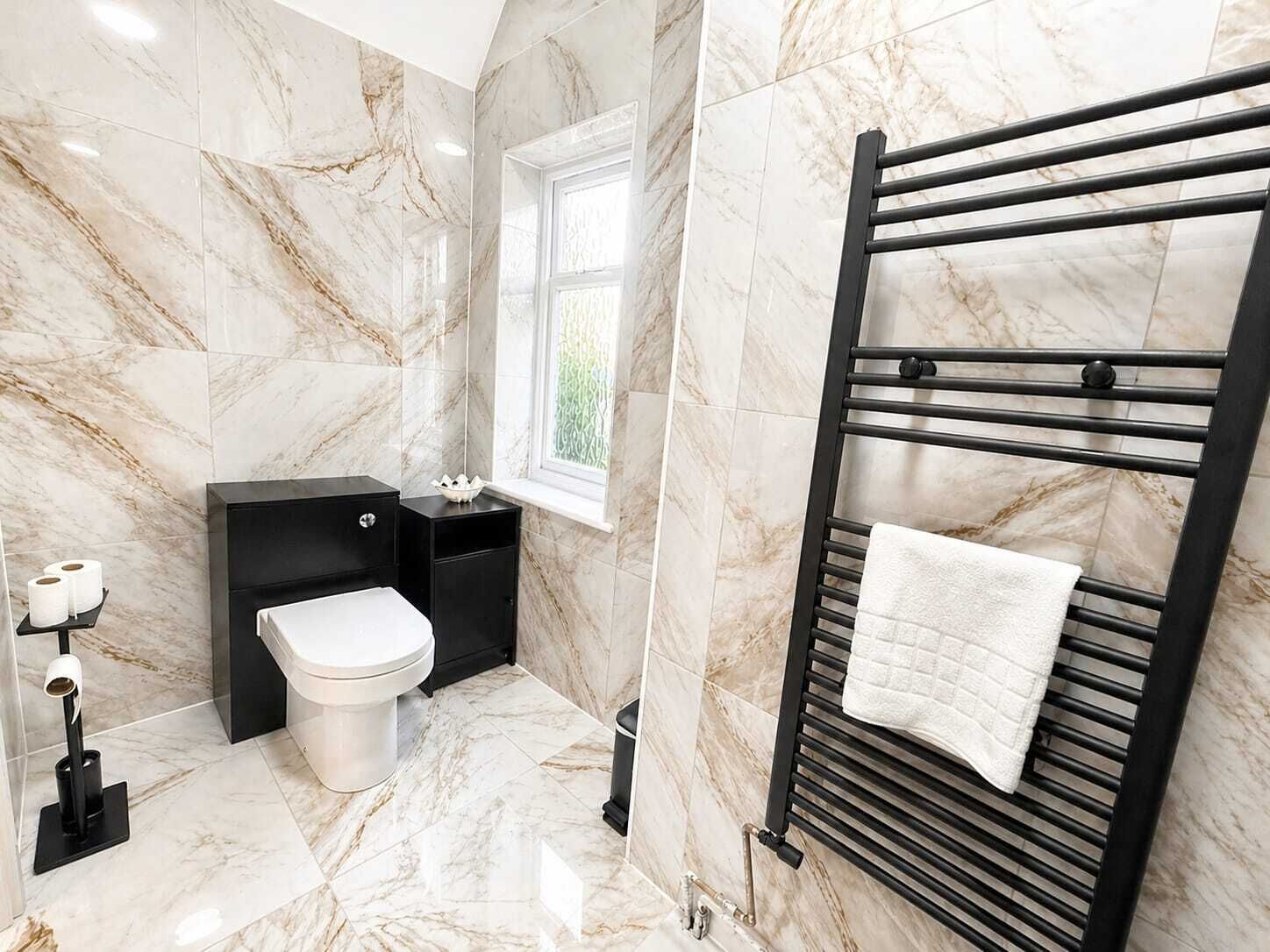 A bathroom with a toilet, sink, and towel rack.
