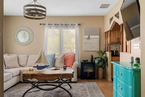 Una sala de estar acogedora con sofá, mesa de centro, chimenea y televisor.
