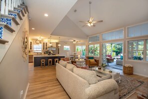 A spacious living area with a large sofa, a dining table, and a kitchen in the background.