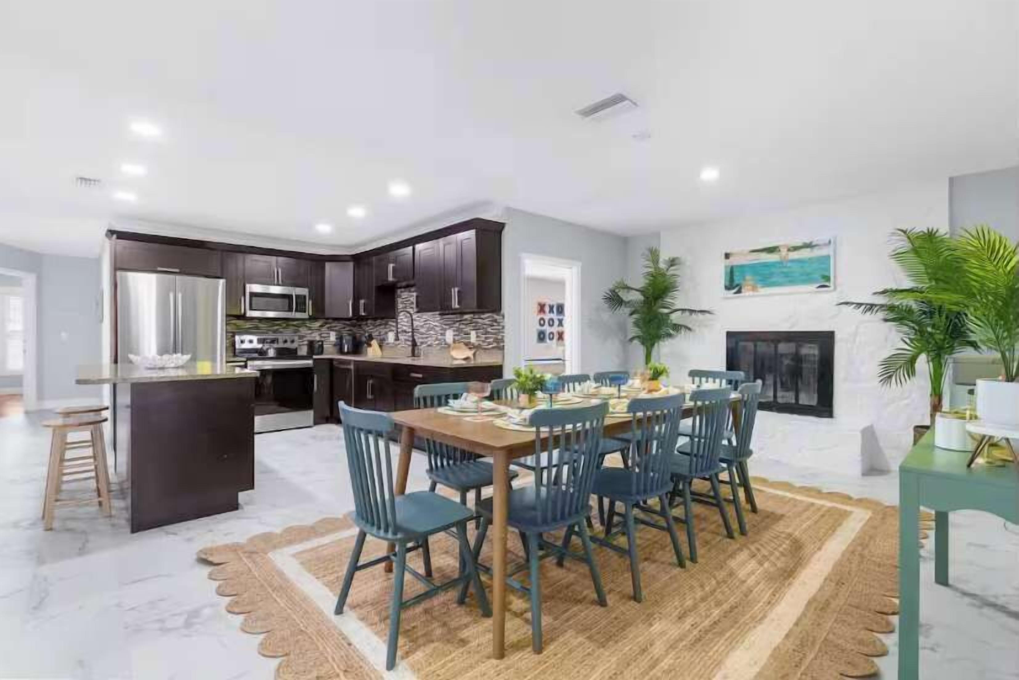 A modern kitchen with dark cabinets, stainless steel appliances, and a central island.