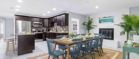 A modern kitchen with dark cabinets, stainless steel appliances, and a central island.