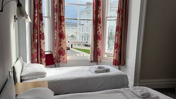 Habitación con 2 camas individuales, vistas al mar | Tabla de planchar con plancha, wifi gratis, ropa de cama