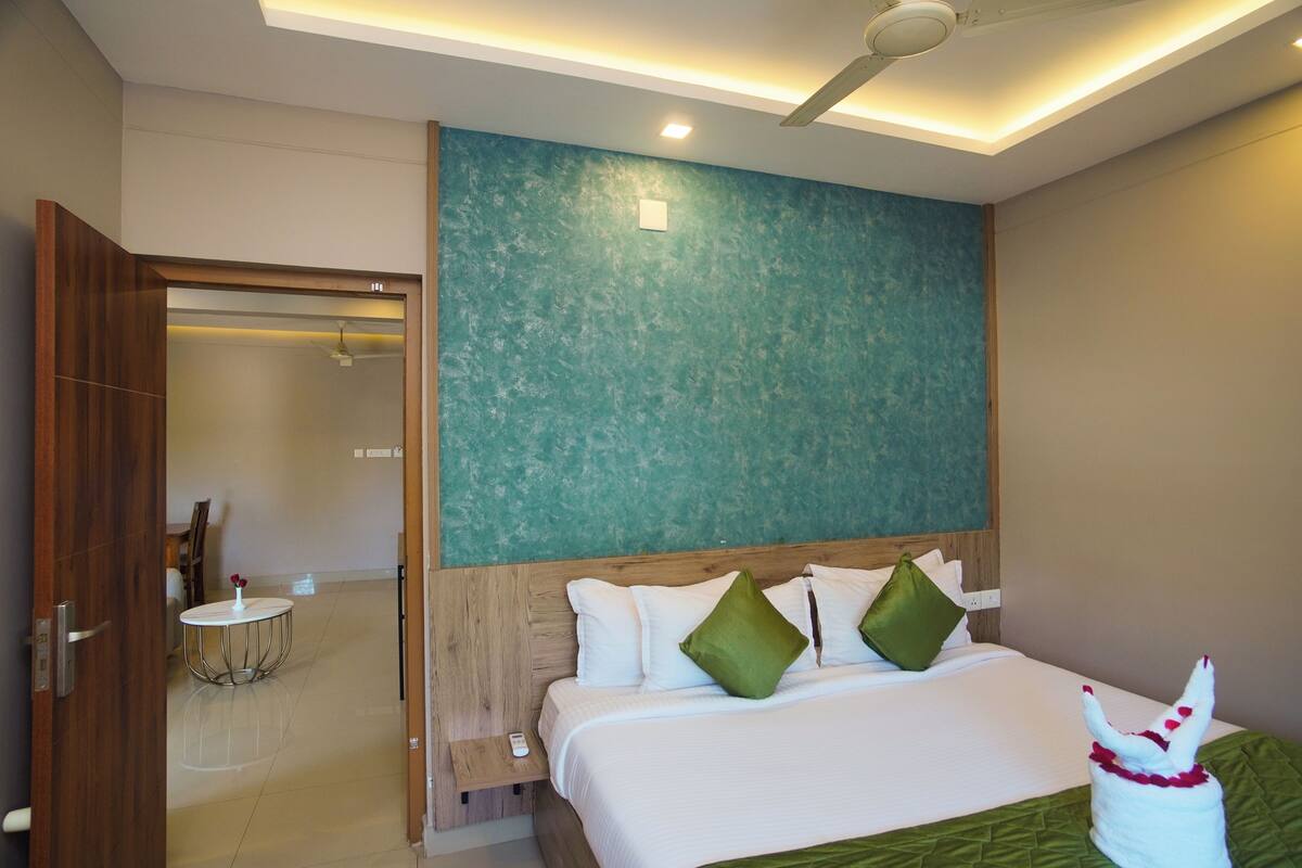 A hotel room with a bed, a round table, and a ceiling fan.