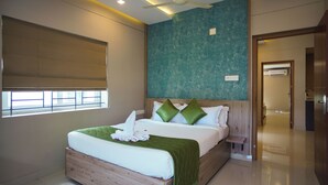 Habitación de hotel moderna con una cama grande, un ventilador de techo y vistas al pasillo.