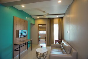 Habitación Deluxe, balcón | Área de sala de estar