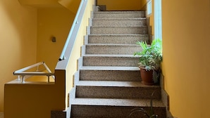 A staircase with granite steps, a handrail, and potted plants. - Hostal Agarimo (Valle de Trapaga)