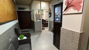 A reception area with a waiting area, a reception desk, and a door labeled 'SALIDA'. - Hostal Agarimo (Valle de Trapaga)