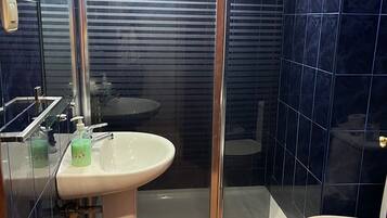 Een douche, handdoeken, toiletpapier